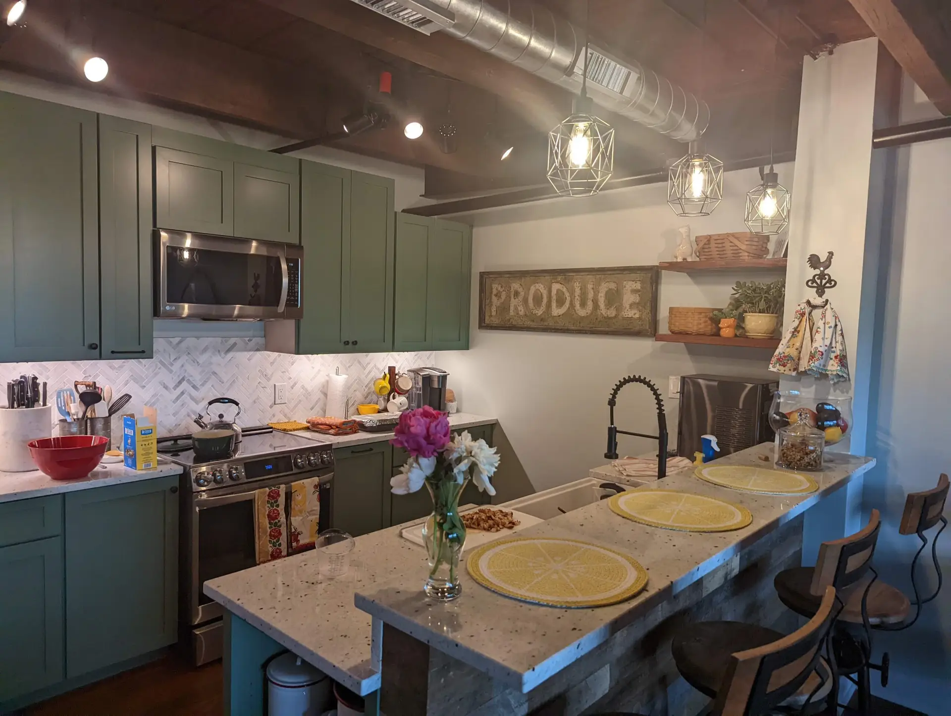 Farmhouse kitchen with teal cabinets, an exposed wood ceiling and a produce sign